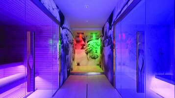 A hallway with a modern design, featuring glass walls and a central light fixture.