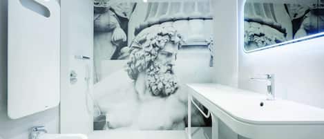 A modern bathroom with a large mirror, a sink, and a shower.