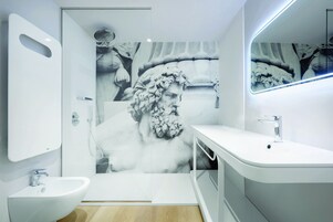 Un bagno moderno con uno specchio grande, un lavandino e una doccia.