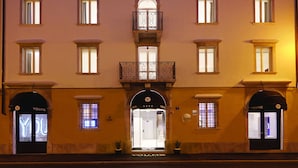 A multi-story hotel with a symmetrical facade, multiple windows, and a central balcony with ornate railings. - You.Me Design Place Hotel (Trieste)