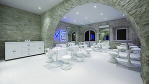 A modern bathroom with white fixtures, stone walls, and a central archway. - You.Me Design Place Hotel (Trieste)