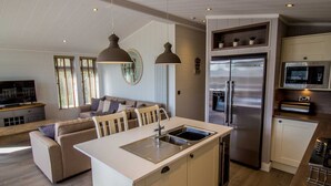 A modern kitchen with a central island, stainless steel appliances, and pendant lighting. - Cedar Lodge | sleeps 8 - Hot Tub, Dog Friendly - 5* Gold Award (PICKERING)
