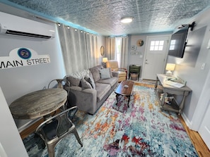 A compact living space with a sofa, coffee table, and a small dining table.