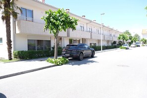 A row of modern apartment buildings with a parked car in front.