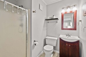 A bathroom with a toilet, sink, mirror, and shower. - Tilghman Beach & Racquet Club 346 - location and amenities galore! (North Myrtle Beach)
