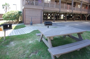 Situated near the building, a picnic table awaits in a well-manicured grassy area.