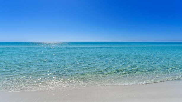 A beach with clear turquoise water and a bright blue sky. - Book 3 Nights & Get 1 Night Free* Charming Cottage*6 Seat Cart*Lake*Beach & Pool (Miramar Beach)