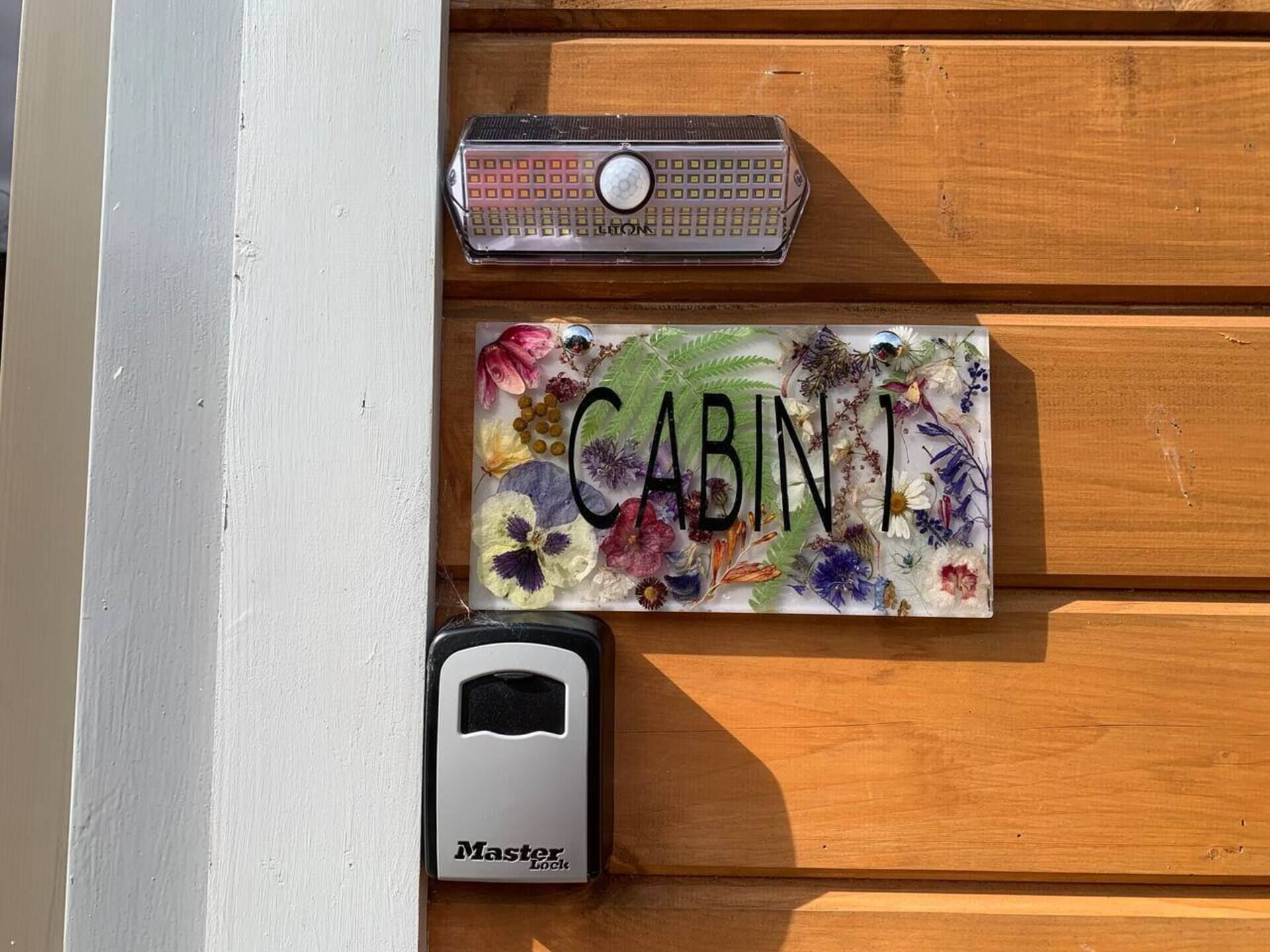 A wooden door with a nameplate that reads "CABINI," a key, and a Master Lock device.