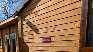 A wooden building with a 'BBQ Zone' sign on the exterior wall. - Immaculate Cabin 5 Mins to Inverness Dog Friendly (Inverness)