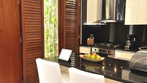 Una cocina moderna con encimera negra, electrodomésticos de acero inoxidable y un cuenco de fruta.