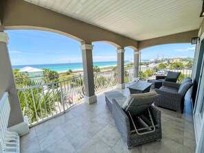 Enjoy ocean views from this balcony with a seating area and wicker furniture.