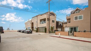 A residential street with modern two-story houses, a clear sky, and parked cars. - 1 House from the Sand w/ Rooftop Deck on 28th Street (Newport Beach)