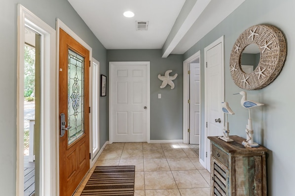 Stylish hallway with a wooden door, glass panel, and decorative starfish.