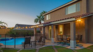 A backyard with a swimming pool, patio furniture, and a covered seating area. - Good Vibes off the strip, 5BR, Secret room, 2 King Beds, Pool and Spa (Henderson)