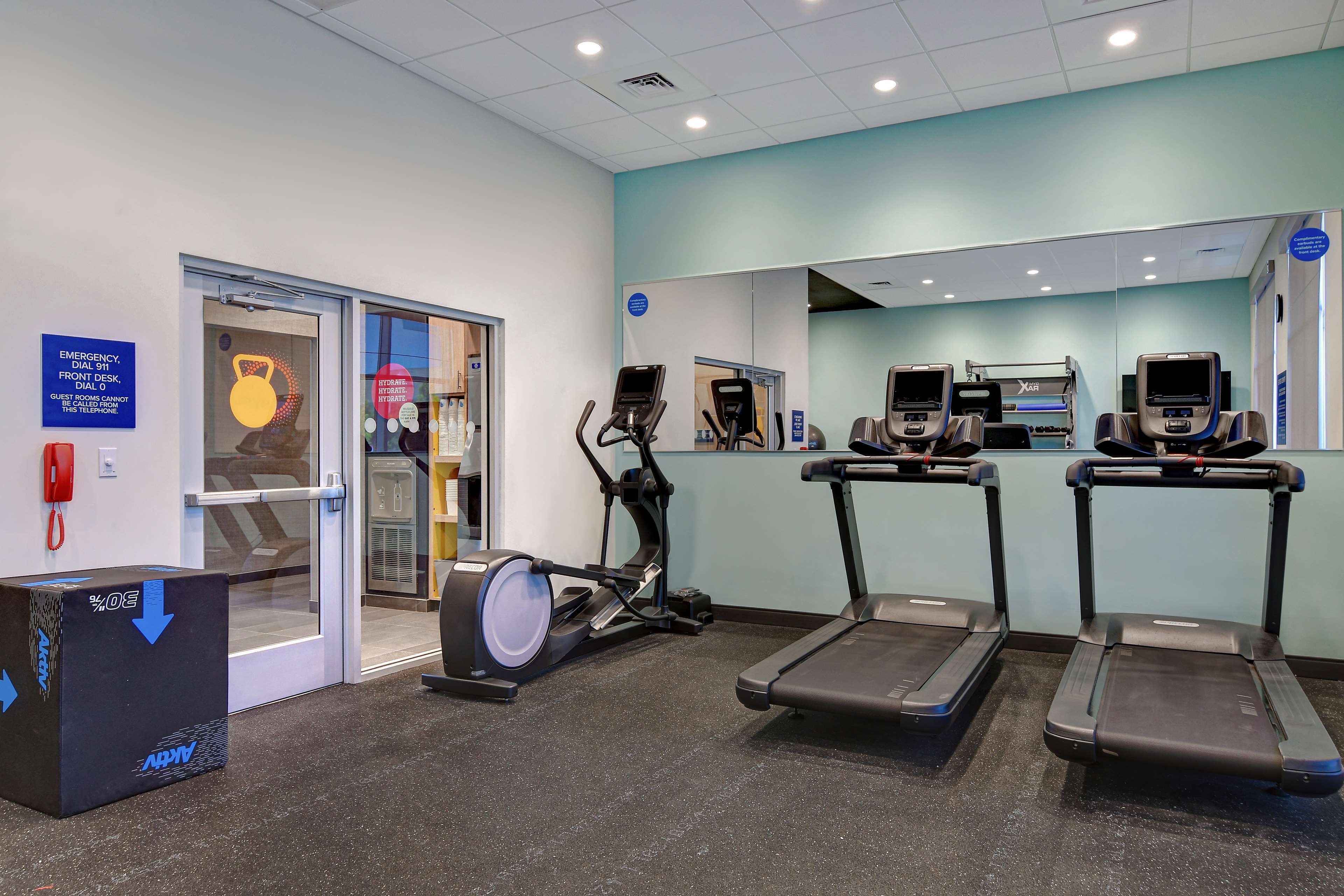 A fitness center with treadmills, an elliptical, and a punching bag.