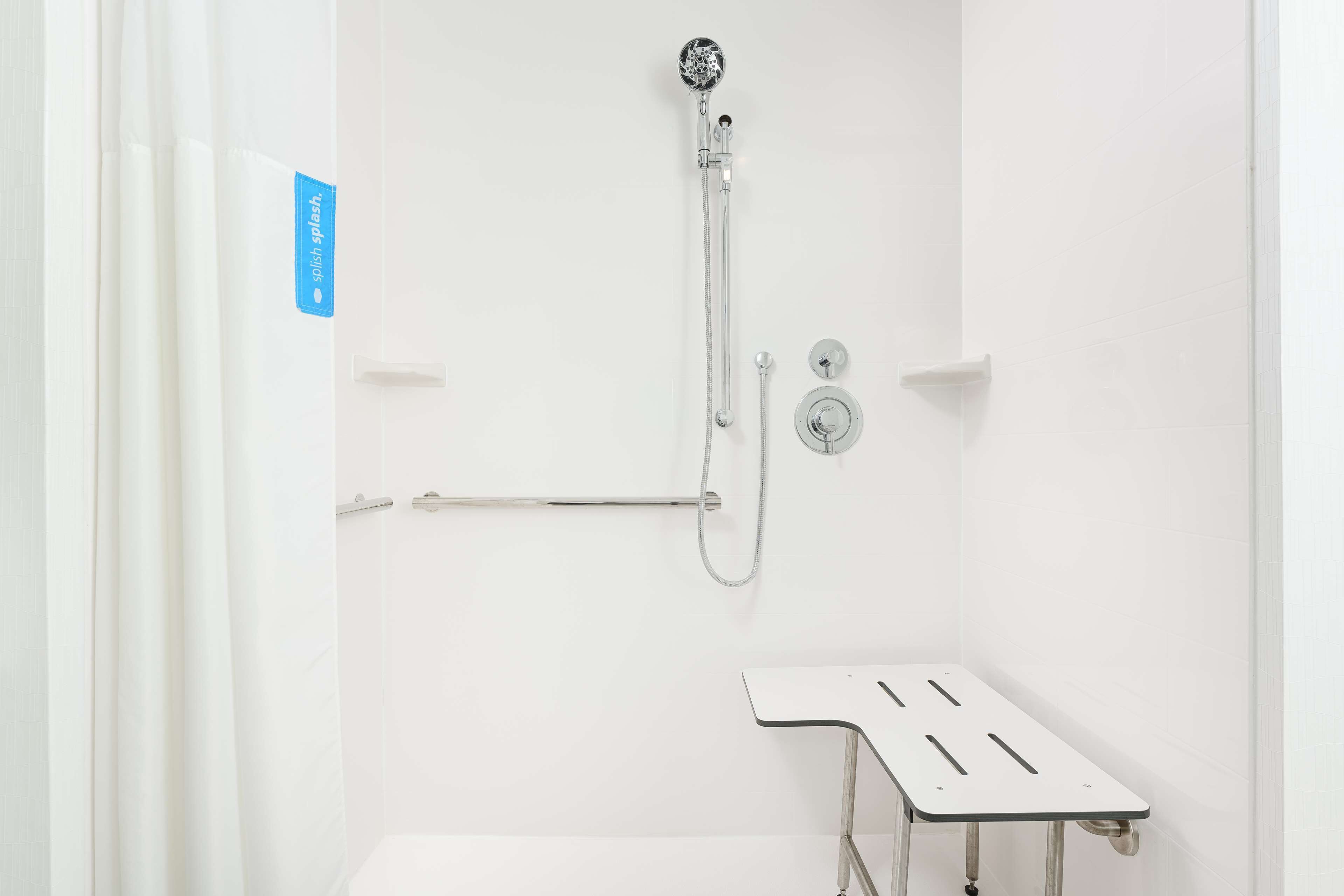 Une douche équipée d’un pommeau de douche à main, d’un flexible de douche et d’un robinet mural.