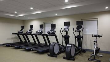 Una palestra con tapis roulant, ellittiche e una cyclette.