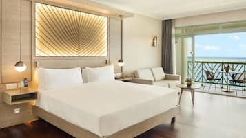 Une chambre d’hôtel moderne dotée d’un grand lit, d’un canapé, d’un balcon avec vue et d’un plafond au design original.