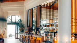 A spacious lobby with a high ceiling, a central bar area, and a seating arrangement.