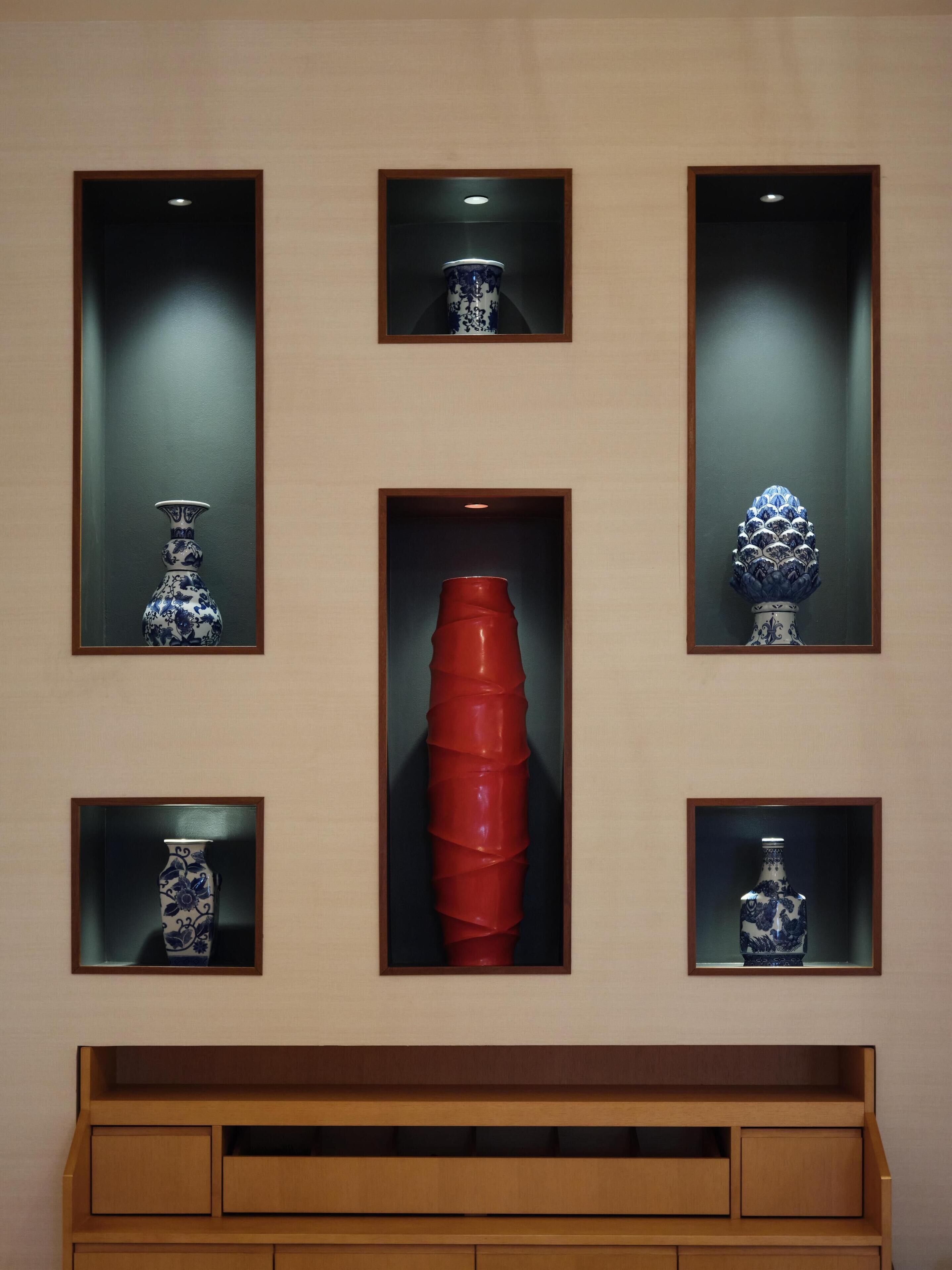 A wall with six display cases, each containing a different object.