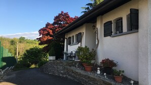 Ein Haus mit Steineinfahrt, Blumentöpfen und blauem Himmel.