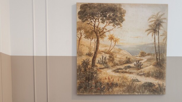 A living room with a grey sofa, a framed landscape painting, a small table with a lamp, and a woven basket. - FLH Amazing Praça Comércio Design Flat (Lisbon)