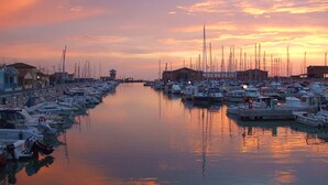 A marina with numerous boats docked along a calm waterway, surrounded by buildings and a clear sky. - Apartment Giglio near the sea (Marina di Grosseto)