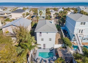 Uma área residencial com casas, piscina e vista para o oceano.