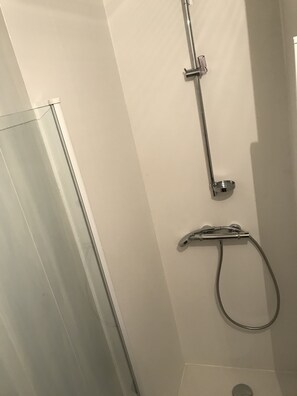 Een douche, een haardroger, handdoeken, toiletpapier