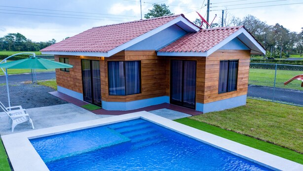 A two-story house with a swimming pool in front. - Sunset Arenal House (La Fortuna)