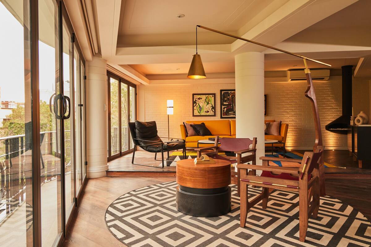 A modern living room with a sofa, chairs, a coffee table, and a patterned rug.