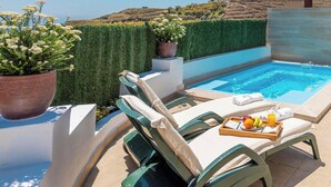 Ein Poolbereich mit Pool, Liegestühlen und einem Tisch mit Früchten und einer Serviertablett.