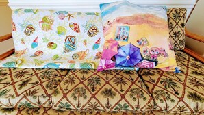 A bed with a patterned bedspread and two pillows with beach-themed designs. - SunSplash,  WALK TO THE BEACH, WALK TO MAIN STREET (North Myrtle Beach)