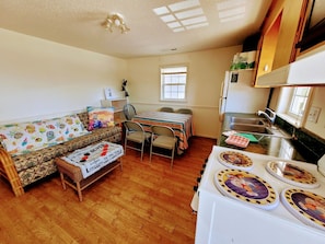 Relax in this inviting space with a sofa, dining table, and stove.