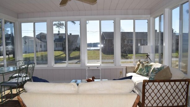 A sunroom with a view of houses and a body of water. - Avocet- Shared Community Water Access, Close to Beach. (Chincoteague)