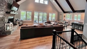 Un loft espacioso con techo alto, chimenea de piedra, ventanas amplias y una zona de estar acogedora.