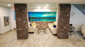 A lobby with two white sofas, a coffee table, and a mural of the aurora borealis. - Manitou Springs Resort (Manitou Beach)