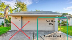 Un garage singolo con un cartello che indica 'Parcheggiare qui solo' e un avviso che specifica 'Un posto per unità'.