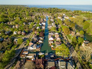An aerial view of a residential area with houses, a river, and a bridge. - The River @ The Park & River Chalet-1BD Upper Unit (Detroit)