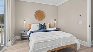 Un dormitorio con cama, lámparas de noche, un adorno en la pared y un termostato.