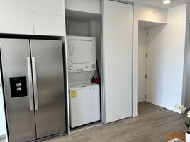 A modern kitchen with a stainless steel refrigerator, a built-in oven, and a microwave.