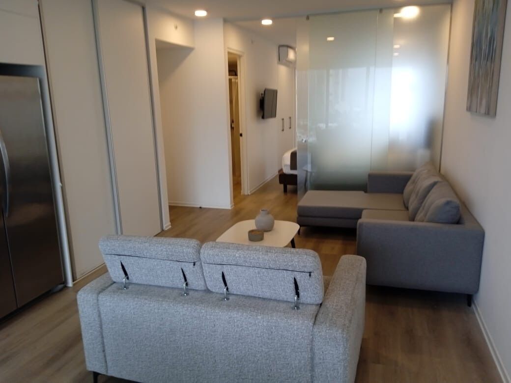Una sala de estar moderna con un sofá gris, una mesita y un diván gris.