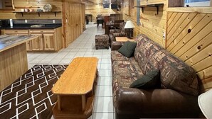 Un intérieur en bois comprenant un canapé, une table basse et un coin cuisine.