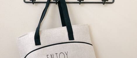 A wall-mounted sign with the words 'STAY AWAY' and a hanging bag with the word 'ENJOY' on it.