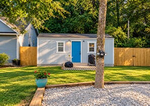 A residential property with a blue door, a covered patio, and a wooden fence. - The Cozy King Studio #1 (Benton)