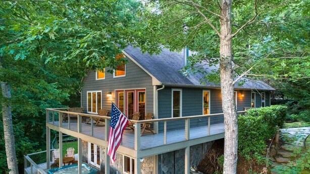 Et toetagers hus med balkon, jacuzzi og et amerikansk flag.