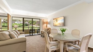 Ein Hotelzimmer mit einem Glastisch, einem beigen Sofa und Blick ins Freie.