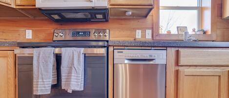 A kitchen with wooden cabinets, a stainless steel oven, a dishwasher, and a microwave.