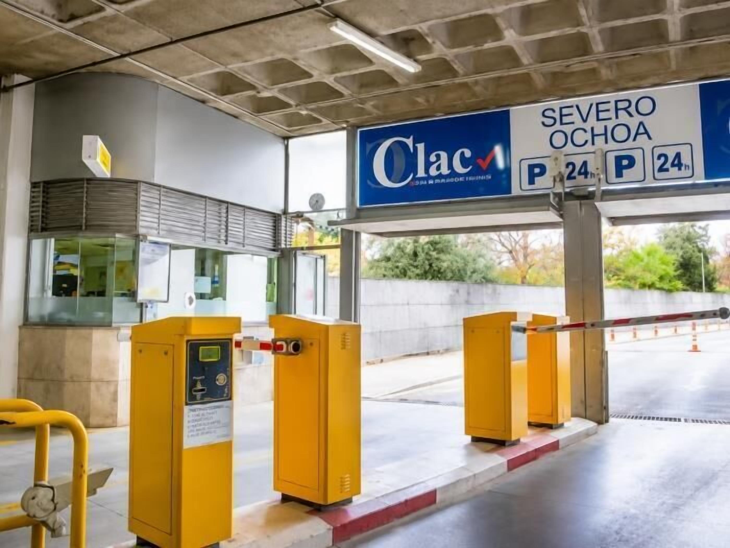 A toll booth with a sign indicating 'Clac' and 'Severo Ochoa' with a 24-hour parking sign.