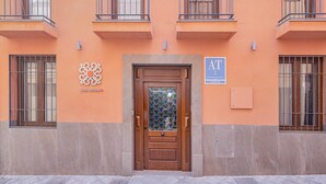 Facciata di un edificio con una porta in legno, finestre sbarrate e una insegna che indica un'attività denominata 'ABALLERIZAS'.